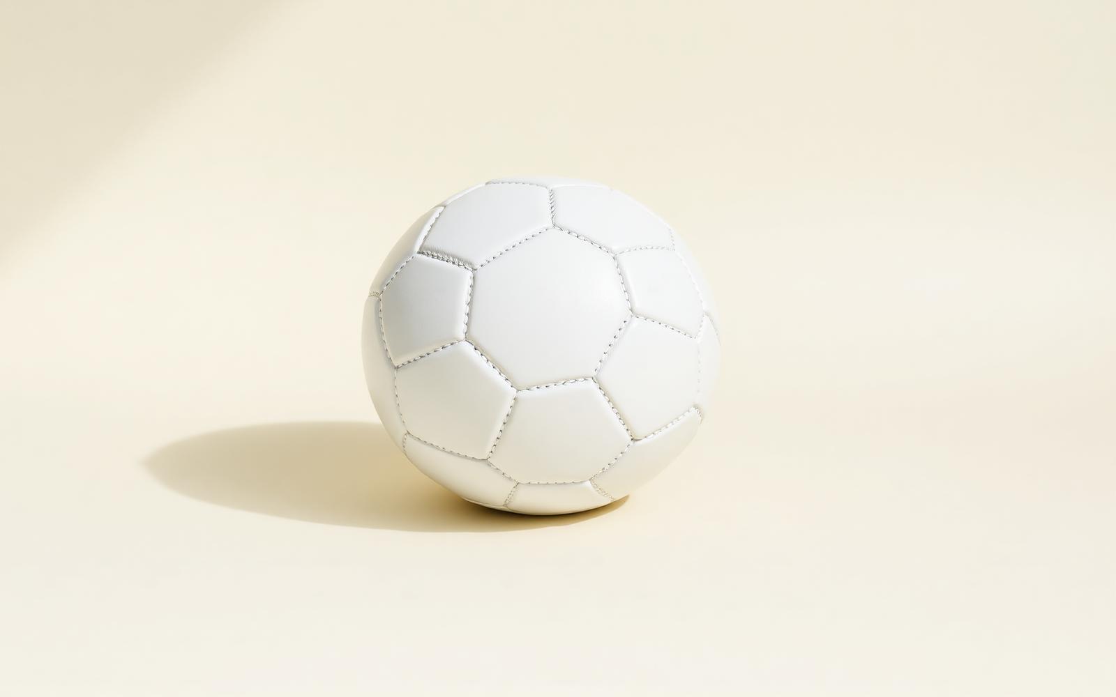 Football on pitch under floodlight